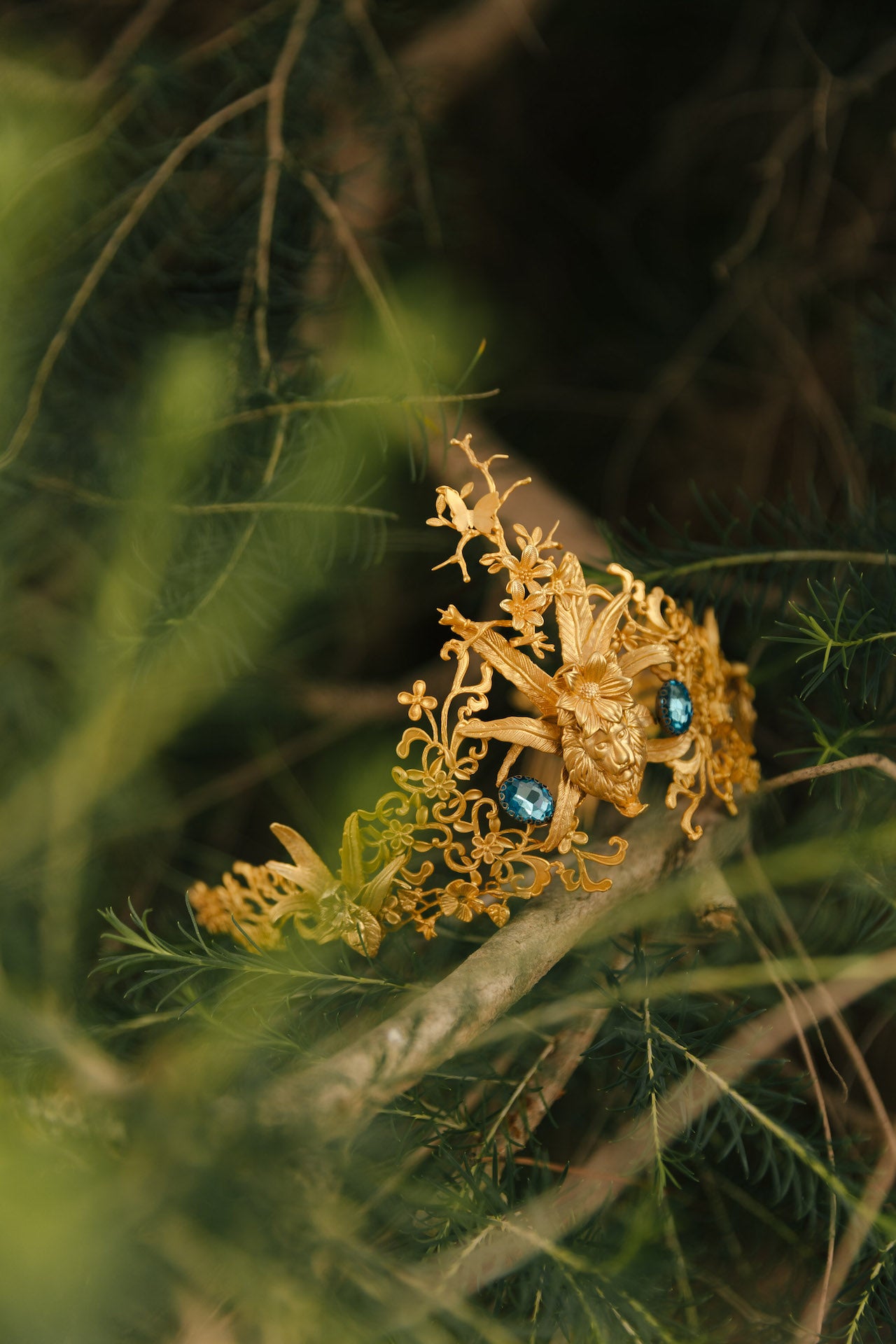 Coroa Mia coroa alta trabalhada com elementos florais e animais, centro em pedras azuis e leão banhada a ouro